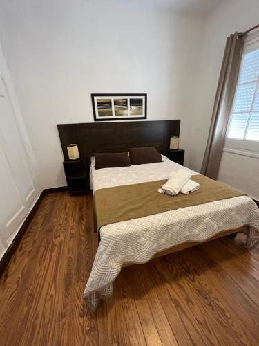 a bedroom with two beds and a wooden floor at Gran Colonial Riviera in Piriápolis