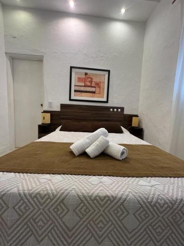 a bedroom with a large bed with two towels on it at Gran Colonial Riviera in Piriápolis