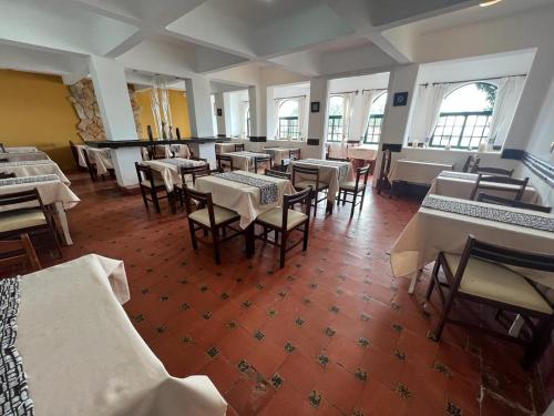 a dining room with tables and chairs and windows at Gran Colonial Riviera in Piriápolis