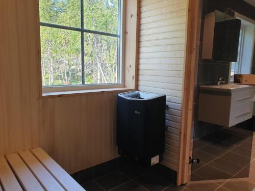 a bathroom with a trash can next to a sink at Bruksvallarna Lullens stugby in Bruksvallarna