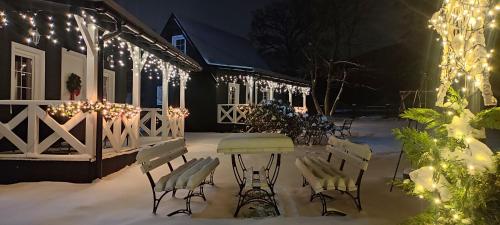 patio con tavolo e sedie nella neve di notte di Domek pod Karpaczem a Miłków