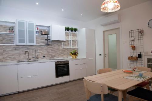 cocina con armarios blancos y mesa de madera en SunGarda Apartment, en Monzambano