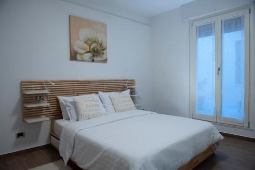 1 dormitorio con 1 cama blanca grande y ventana en SunGarda Apartment, en Monzambano
