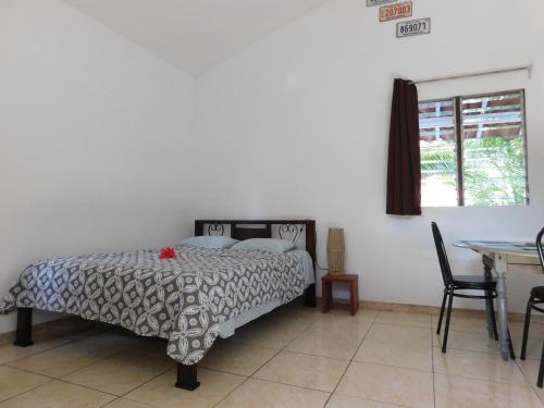 薩馬拉的住宿－Villasjungle 1，一间卧室配有一张床、一张桌子和一个窗户。