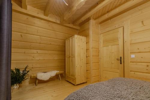 a log cabin with a bed and a door at Domek Na Przełęczy wood house & mountain view in Murzasichle
