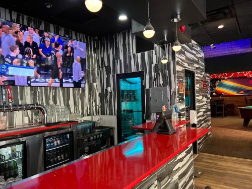 a bar with a red counter and a flat screen tv at Commercial Hotel in Edmonton