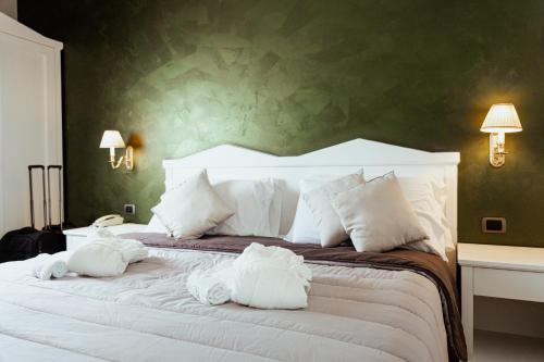 een slaapkamer met een groot bed en handdoeken bij Tuo Hotel in Polignano a Mare