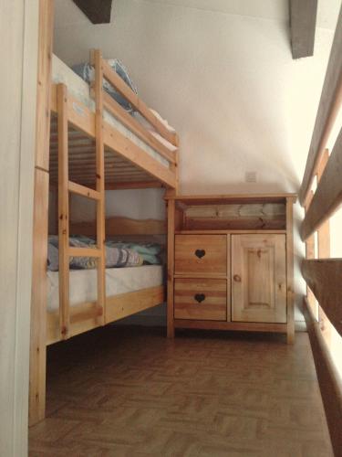 - une chambre avec 2 lits superposés et une armoire en bois dans l'établissement Appartement à Lanslevillard station Val Cenis Vanoise, à Lanslevillard