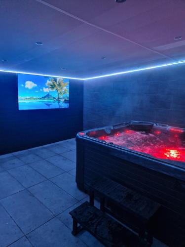 a room with a large tub with red water at Short Stopzzz & Indoor Hot Tub in Manchester
