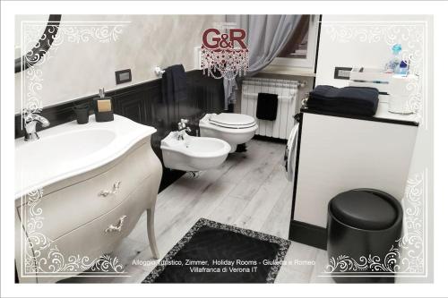 ein Badezimmer mit einem weißen Waschbecken und einem WC in der Unterkunft Alloggio Turistico Giulietta e ROMEO Intero Appartamento Centro Villafranca di Verona, Zimmer, Holiday Rooms in Villafranca di Verona