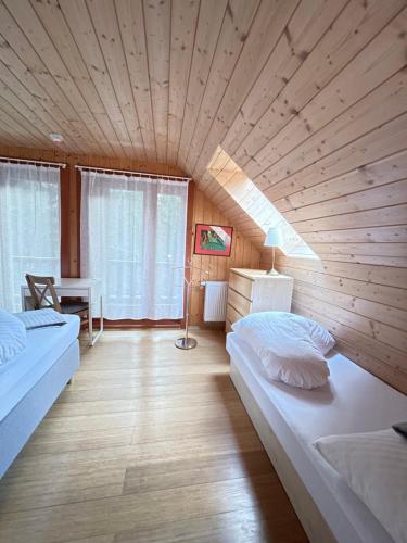 a bedroom with two beds and a wooden ceiling at Chata Marína a Matej Kubínska hoľa in Dolný Kubín