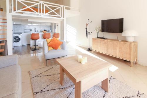 un salon avec une table et une télévision dans l'établissement Beautiful Renovated Studio with AC and TERRACE - Benakey, à Cannes