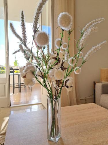 un vase rempli de fleurs posé sur une table dans l'établissement Beautiful Renovated Studio with AC and TERRACE - Benakey, à Cannes