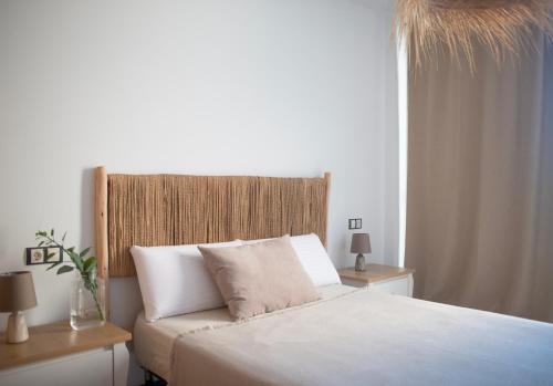 um quarto com uma cama com lençóis brancos e uma janela em Cozy 1 Bedroom Apartment with Sea View em Cotillo