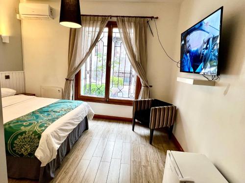 - une chambre avec un lit et une télévision murale dans l'établissement HOTEL BOUTIQUE CASA NOBLE SPA, à Santiago