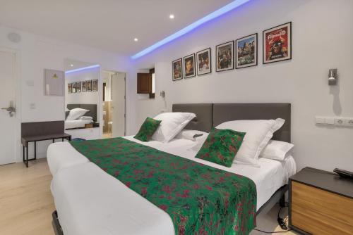 a bedroom with two white beds with green sheets at Hotel Ronda Nuevo in Ronda