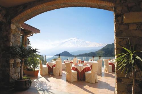 a restaurant with a view of a snow covered mountain at Hotel Villa Sonia in Taormina