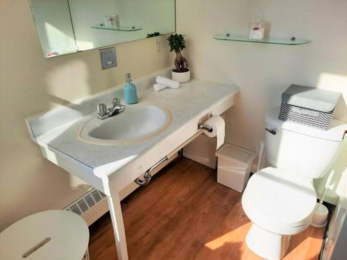 a bathroom with a white sink and a toilet at Hip Studio w/City Views Minutes to DT in Calgary