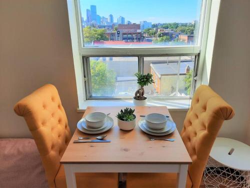 a table with two chairs in front of a window at Hip Studio w/City Views Minutes to DT in Calgary