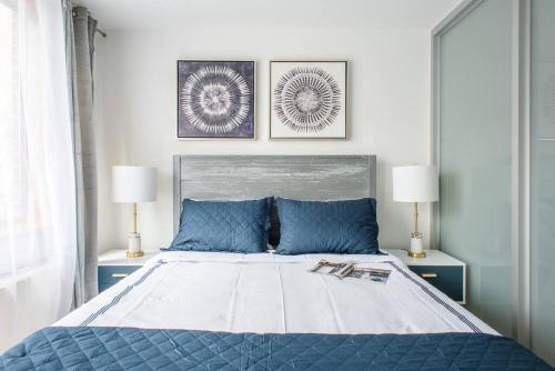 a bedroom with a bed with blue pillows and two lamps at 75-1D New 1BR prime UES W D the unit Best Value in New York