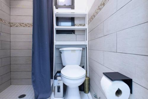 a bathroom with a toilet and a blue shower curtain at 428-2W Newly Furnished Prime Location 2BR Sleeps 5 in New York