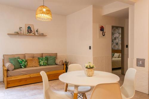 ein Wohnzimmer mit Sofa und Tisch in der Unterkunft Departamento Céntrico Belgrano PBE in San Carlos de Bariloche