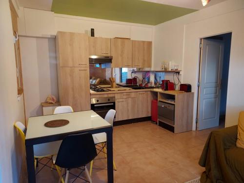 eine Küche mit einem Tisch und Stühlen im Zimmer in der Unterkunft Le cottage du Littoral de Petit Havre in Le Gosier