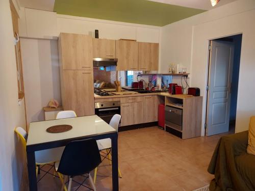 a kitchen with a table and chairs in a room at Le cottage du Littoral de Petit Havre in Le Gosier