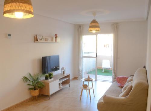a living room with a couch and a tv at Dunas de Águilas in Águilas