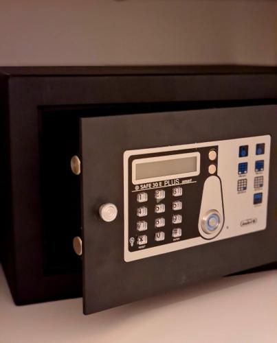 a microwave oven with a calculator on top of it at Amberdi Apartment Amsterdam Schiphol Airport in Hoofddorp