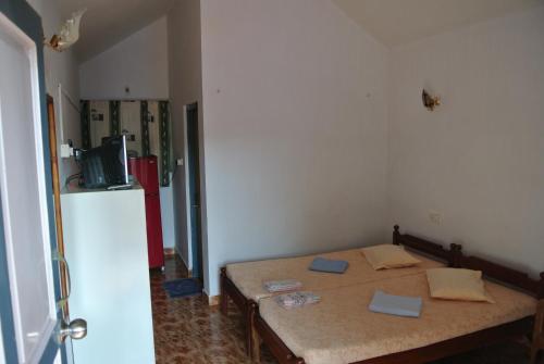 Habitación pequeña con mesa y nevera. en Arjun Villa Guest House, en Anjuna