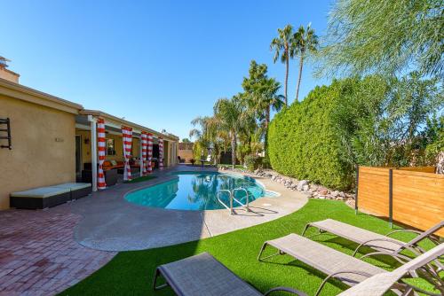 una piscina en un patio con sillas y árboles en Casa Del Mar home, en Scottsdale
