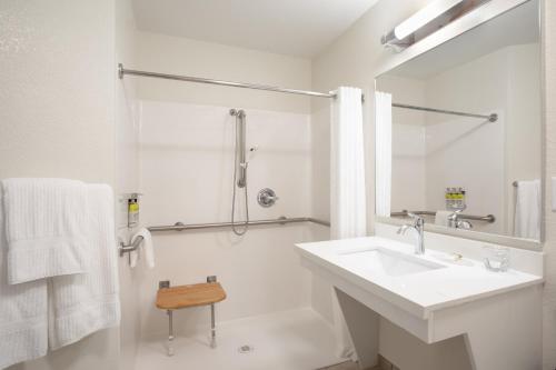uma casa de banho branca com um lavatório e um chuveiro em Candlewood Suites Cheyenne, an IHG Hotel em Cheyenne