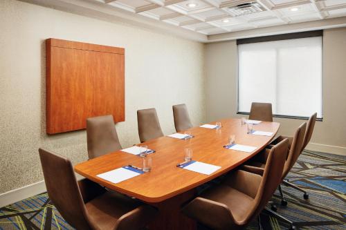 a conference room with a large wooden table and chairs at Holiday Inn Express & Suites Jacksonville South East - Medical Center Area by IHG in Jacksonville