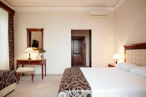 a bedroom with a bed and a desk and a mirror at Hotel Villa Schubert in Ičići