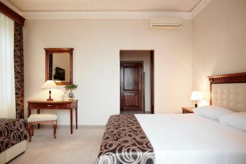 sypialnia z łóżkiem, biurkiem i lustrem w obiekcie Hotel Villa Schubert w mieście Opatija