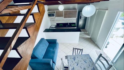 a small kitchen with a staircase and a blue couch at Residencial Morro do Macaco in Bombinhas
