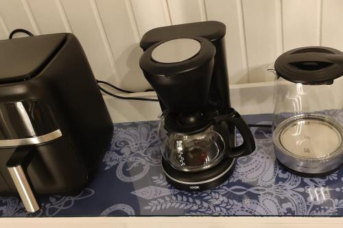 a black coffee maker sitting on top of a table at Villa Pikkumustikka in Töysä
