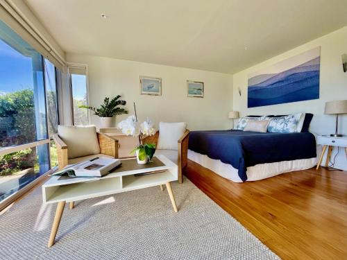 a bedroom with a bed and a table at Watermark Apartments in Oneroa