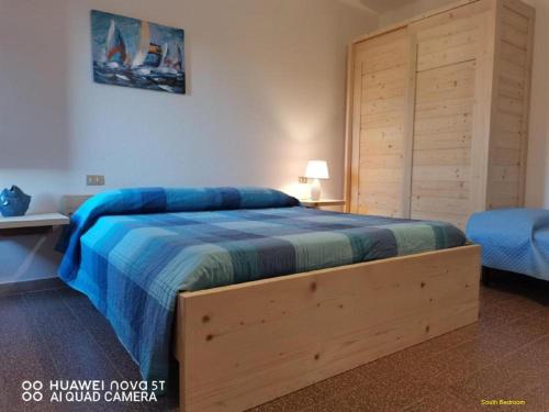 1 dormitorio con 1 cama con cabecero de madera en Sant'Antioco island Sea View an Exclusive Villa by the Sea with extra Privacy & Care, en Maladroscia