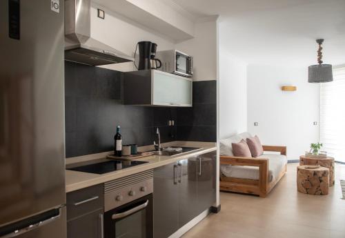 een keuken met roestvrijstalen apparatuur en een woonkamer bij Ocean View Penthouse El Cotillo in Cotillo