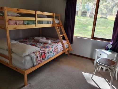 a bedroom with a bunk bed and a chair at Redgate Homestead in Hartley