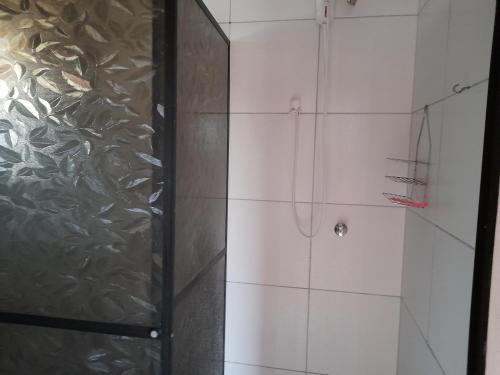 a shower with a glass door in a bathroom at Hospedagem Tia Nena in Pomerode