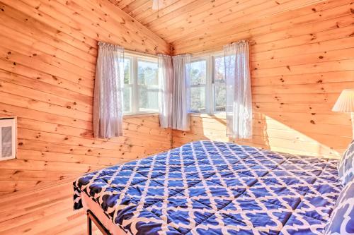 a bedroom with a bed in a log cabin at Near Hiking Lakefront Albrightsville Home with Deck in Albrightsville