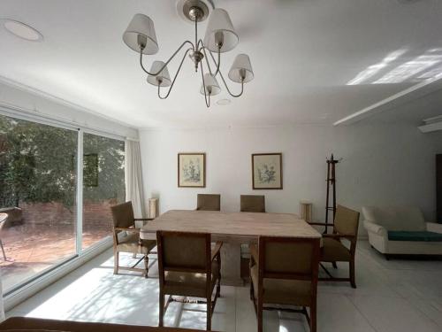 a dining room with a table and chairs and a chandelier at Amplia Casa cerca de Aristdes con Patio y Parilla in Mendoza