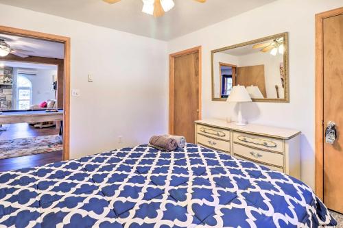 a bedroom with a blue and white bed and a mirror at Near Hiking Lakefront Albrightsville Home with Deck in Albrightsville