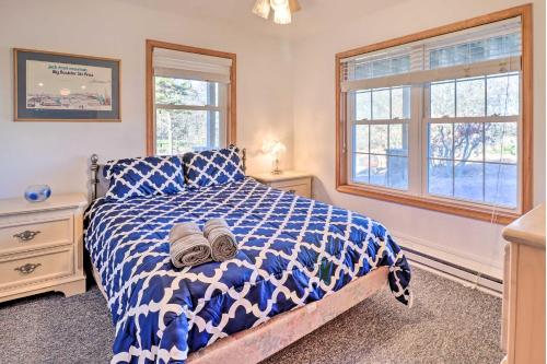 a bedroom with a blue and white bed and windows at Near Hiking Lakefront Albrightsville Home with Deck in Albrightsville
