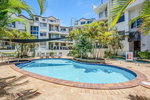 a swimming pool in front of a building at Sandcastles On Currumbin Beachfront, Gold Coast in Gold Coast