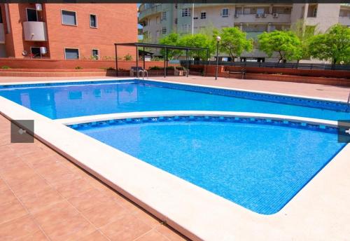 ein großer Pool mit blauem Wasser in einem Gebäude in der Unterkunft Apartamento Galea in Santa Pola