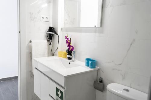 a white bathroom with a sink and a toilet at Almada Downtown 101 in Porto